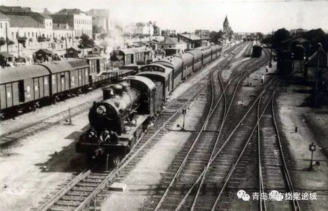 1935年,一列客货混合列车驶出青岛站,远方尖顶为青岛站钟楼.