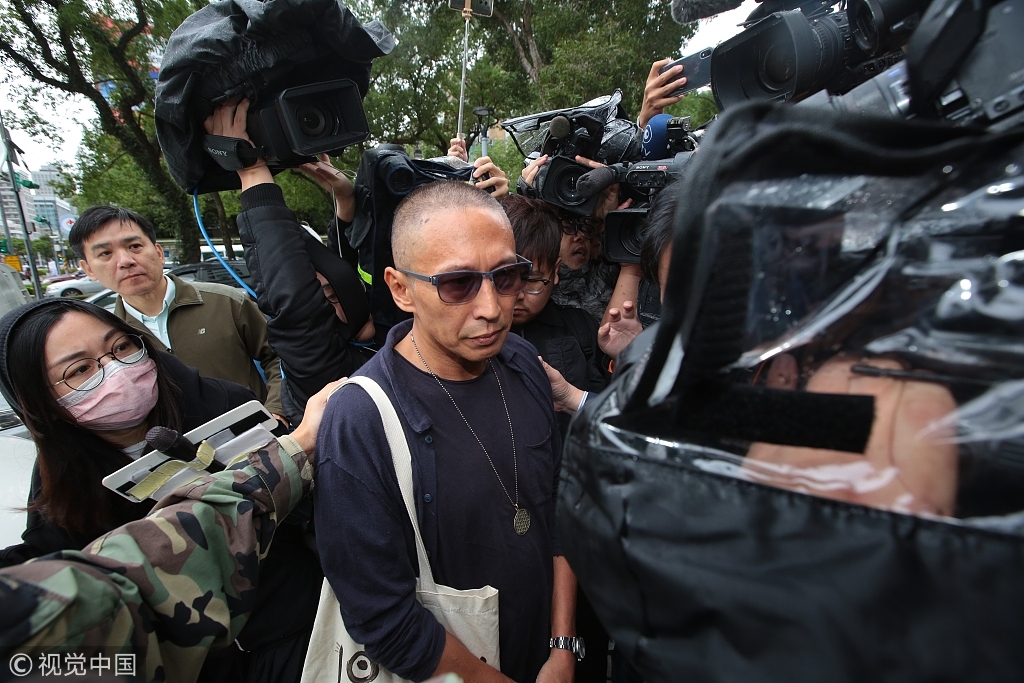 导演钮承泽剃光头背帆布包赴警局应讯 面对媒体一路沉默