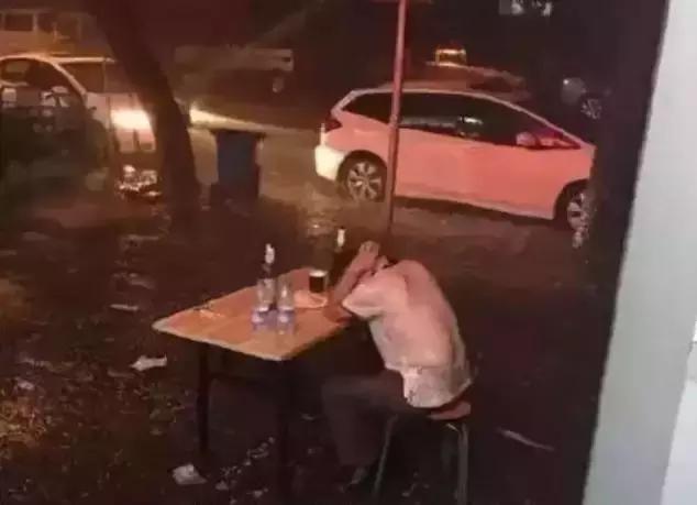 深夜里,一个男人坐在路边的大雨中喝酒,突然嚎啕大哭