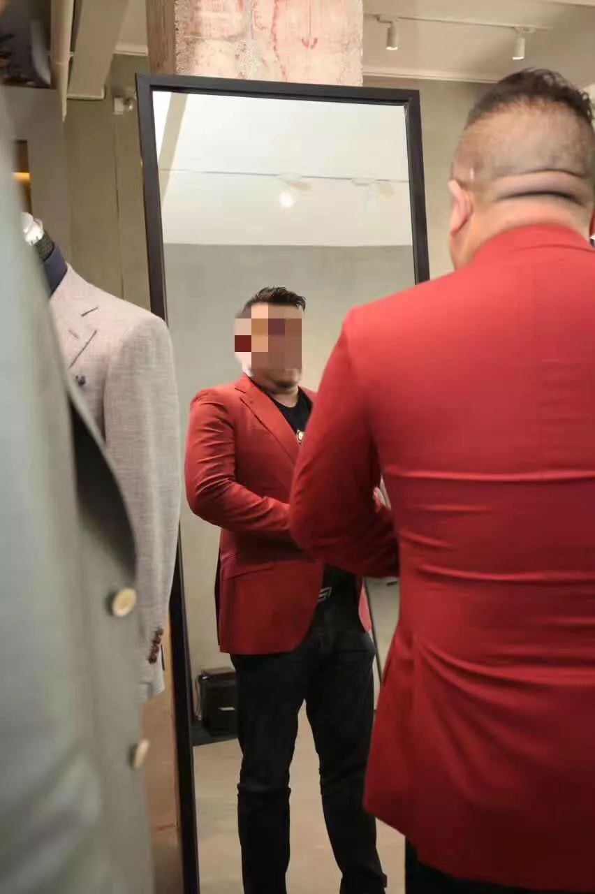 孙小果在昆明一家定制西装店试装,拍摄时间2018年。受访者供图。