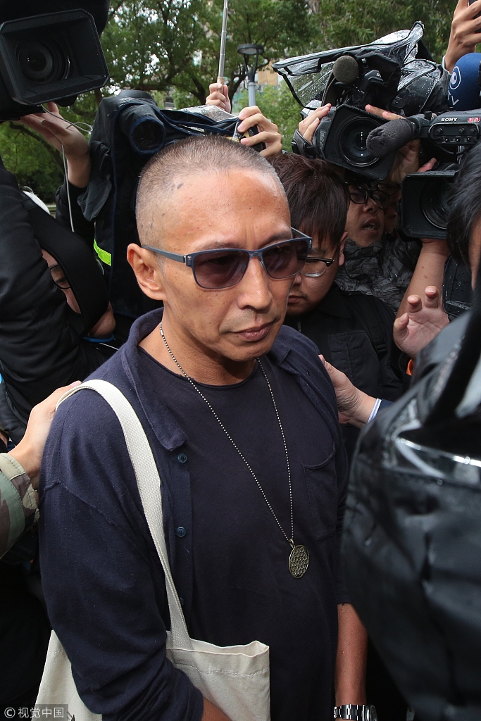 导演钮承泽剃光头背帆布包赴警局应讯 面对媒体一路沉默