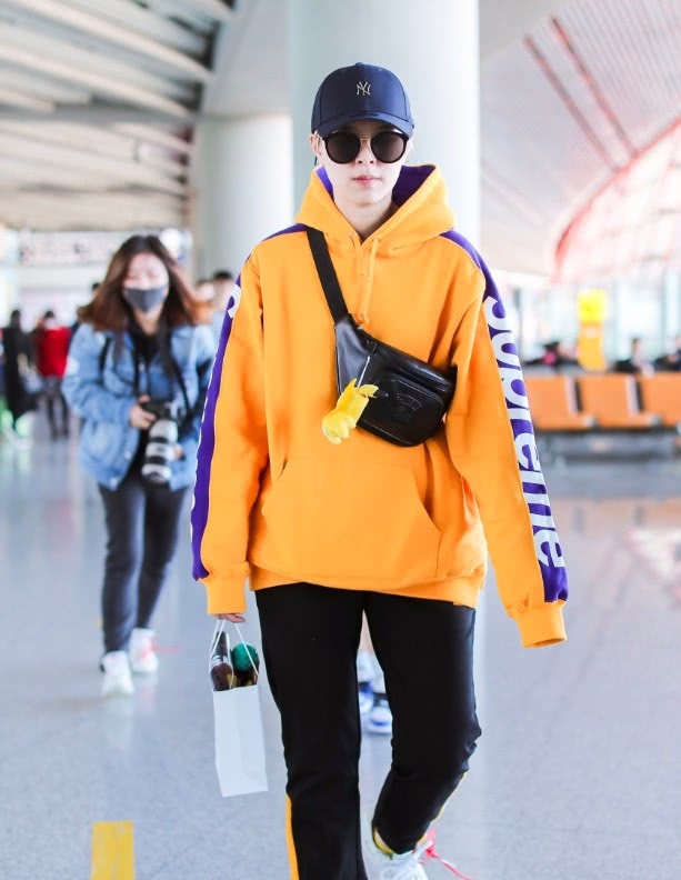 杨芸晴身穿橘色卫衣现身机场,搭配黑色运动裤