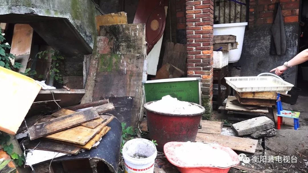 这家豆制品小作坊,只见门口一侧堆积了不少废弃的木料,另一侧堆放着