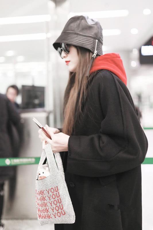 唐嫣穿一件黑色风衣出门,配上大红色卫衣,这俩