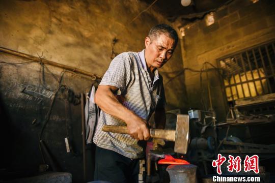 打造一把普通菜刀要经过至少5000次的锤打 侯康 摄