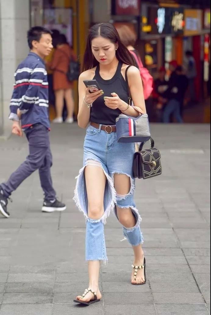 美女挂脖背心配破洞牛仔裤,轻松绽放迷人的身
