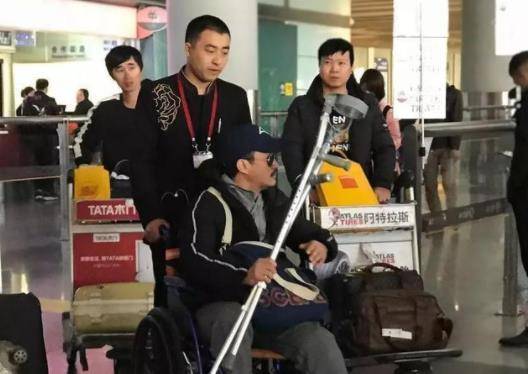 吴京坐轮椅现身机场 表情严肃没有笑容