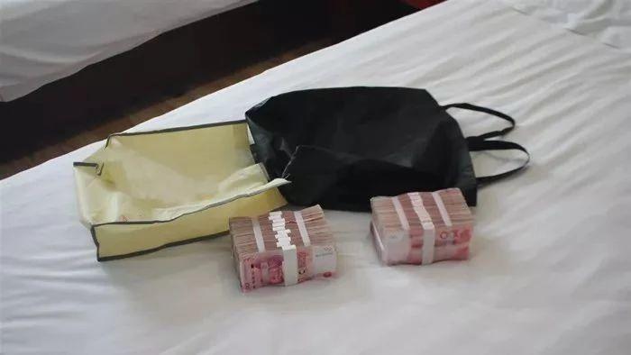发现该房间的纸篓内有一个黑色手提袋,袋内放有两捆用纸条捆扎面值100