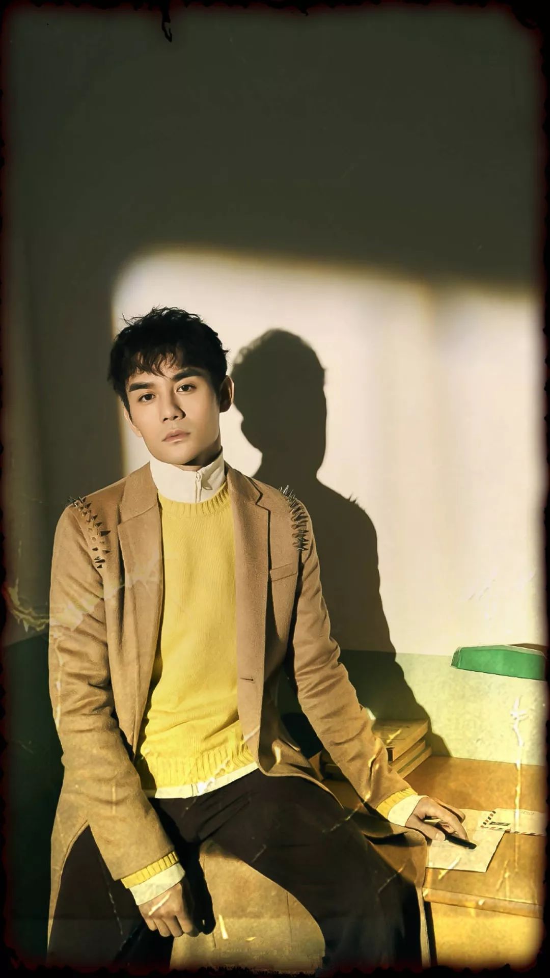 王凯身穿驼色的大衣,内搭黄色的毛衣,叠穿白色的拉链针织开衫,温暖