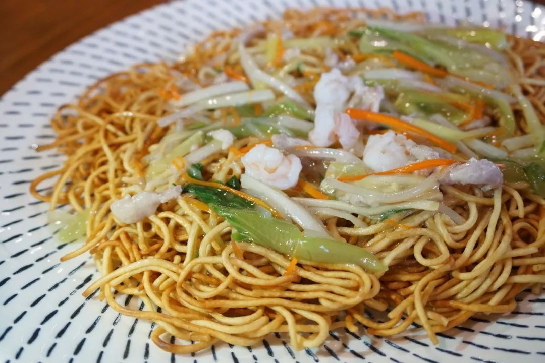 两面黄是上海比较古老的小吃,店里有 2种浇头,柠檬点了经典虾仁的,上