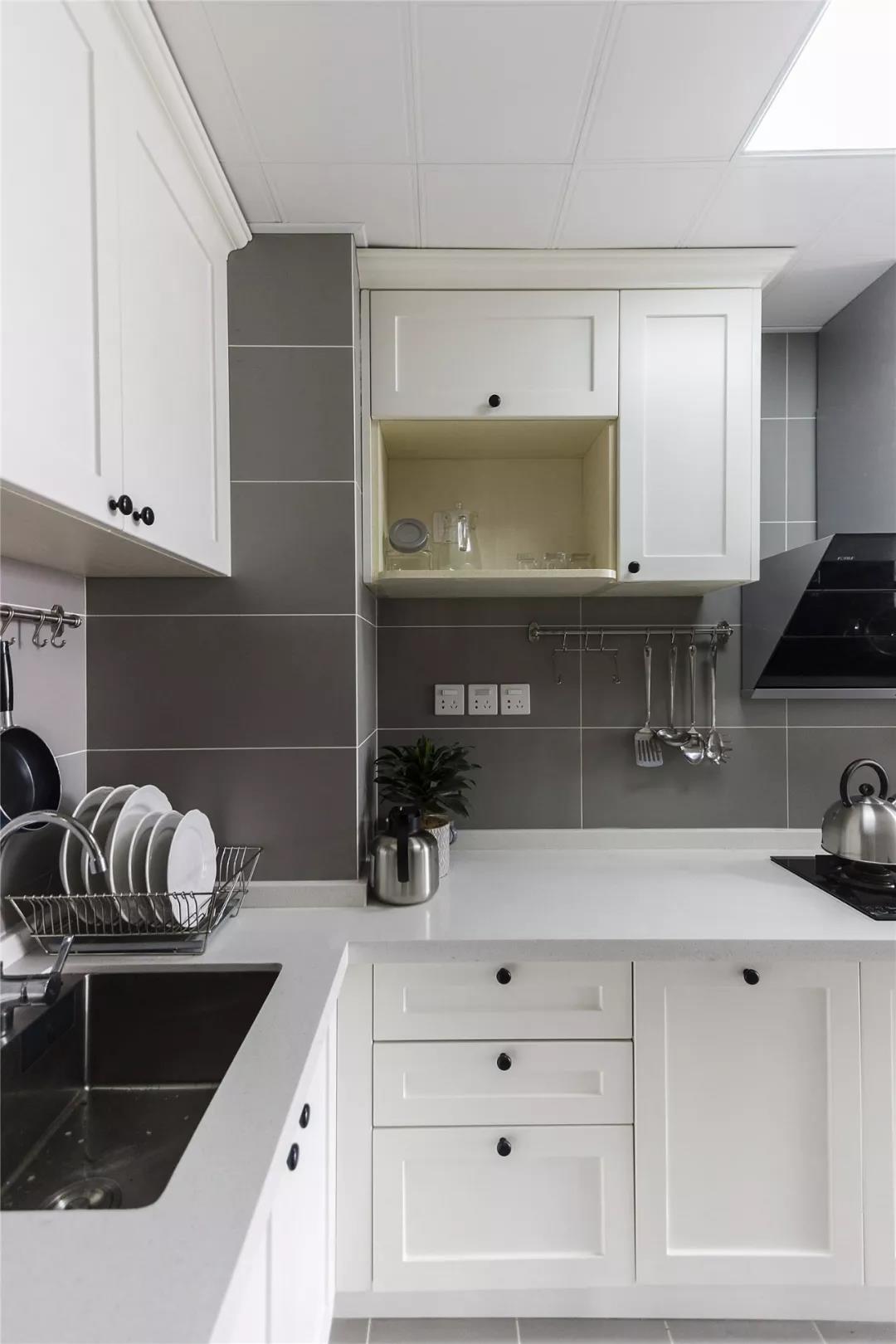 厨房柜子都是白色,墙砖和地砖灰色的