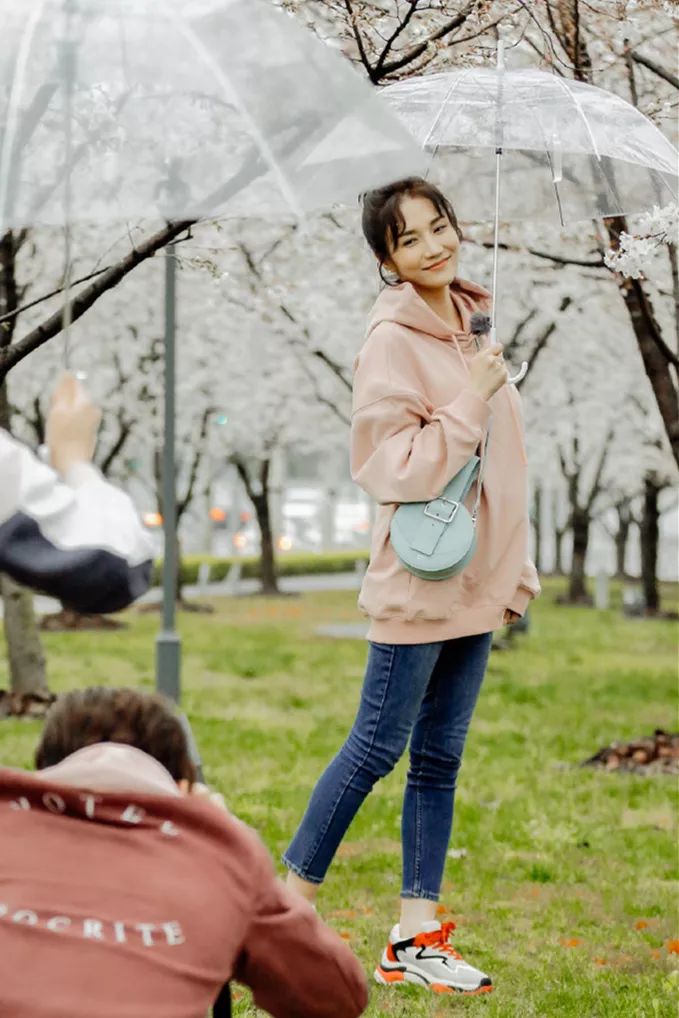 oversize的连帽卫衣更衬其身材娇小玲珑,而下身用一条修身款的深蓝色