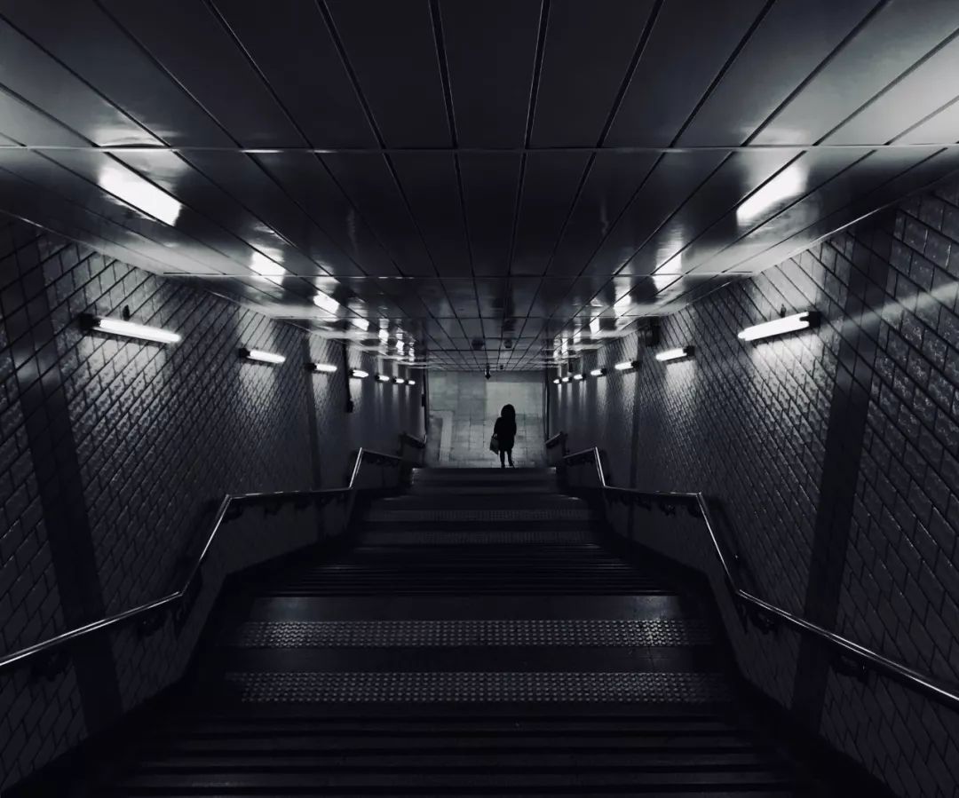 通过长焦镜头将老师的背影与黑白上的字框取在一起,体现毕业离别这一